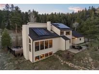 Stunning contemporary home with solar panels and inviting outdoor seating areas at 33379 Buffalo Park Rd, Evergreen, CO 80439