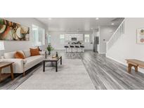 Bright open-concept living room featuring hardwood floors and a comfortable sofa at 12941 Delaware St, Westminster, CO 80234