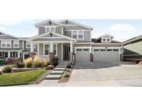 Charming two-story home featuring a well-manicured lawn, a two-car garage, and inviting front porch at 6143 Eldora St, Golden, CO 80403