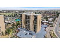 An exterior view of a modern high-rise condominium complex with a parking area and green spaces at 7877 E Mississippi Ave # 607, Denver, CO 80247