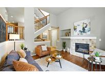Cozy living room features a fireplace, hardwood floors, and neutral decor at 1100 Rockhurst Dr # A, Highlands Ranch, CO 80129