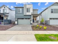 Two-story home featuring a two-car garage, modern architectural details, and manicured landscaping at 19058 E 94Th Pl, Commerce City, CO 80022