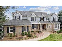 Stately two-story home featuring a brick and gray facade, complemented by mature landscaping and a welcoming walkway at 20363 E Top T Ranch Pl, Parker, CO 80134