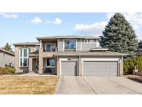 Inviting two-story home with a combination of brick and siding, showcasing a well-manicured lawn and a two car garage at 6681 Millstone Pl, Highlands Ranch, CO 80130