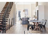 Bright open-concept living area with floating staircase, modern kitchen, and dining area at 5125 W 29Th Ave # 5, Denver, CO 80212