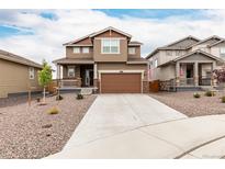 Two-story home with brown siding, a concrete driveway and a two-car garage at 870 Mosquito Ct, Elizabeth, CO 80107