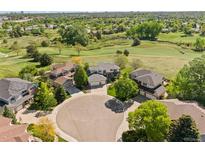 Stunning aerial view of homes on a cul-de-sac with golf course and lush green landscape at 8806 Tuscany Ln, Highlands Ranch, CO 80130