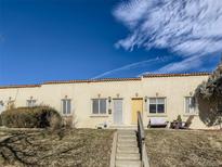 Charming townhomes with a Spanish tile roof line and steps leading to the units' front doors at 3081 W 18Th Ave, Denver, CO 80204