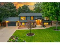 Charming two-story home with a manicured lawn, lush landscaping, and inviting front porch at 20520 E Regency Way, Parker, CO 80138