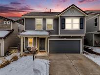 Charming two-story home with gray siding, a two-car garage, and a cozy covered front porch at 2418 Coach House Loop, Castle Rock, CO 80109