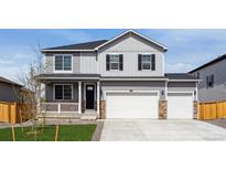 Charming two-story home with a three car garage, gray siding, black shutters, stone accents, and a cozy front porch at 4211 Sandstone Dr, Mead, CO 80504