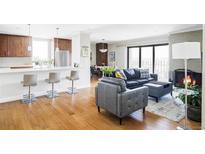 Bright living room showcasing a modern fireplace, hardwood floors, and seamless open-concept design at 460 S Marion Pkwy # 1701, Denver, CO 80209