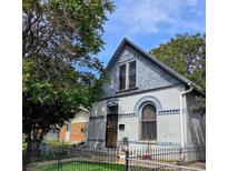 Charming home featuring unique architectural details, light grey brick, and a well-maintained front yard with trees at 4316 Josephine St, Denver, CO 80216