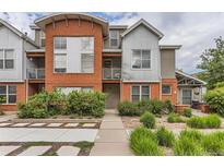 Contemporary townhome featuring a brick and metal facade and a welcoming landscaped entrance at 85 Uinta Way # 702, Denver, CO 80230