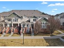 Inviting townhouse exterior featuring well-maintained lawns, brick accents, and charming entrances at 1443 S Emporia Ct, Aurora, CO 80247