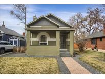 Charming bungalow with a brick facade, covered porch and well-manicured front lawn at 4017 King St, Denver, CO 80211