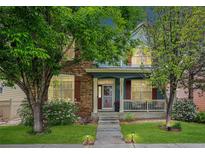 Charming home featuring a well-manicured lawn, mature trees, and a welcoming front porch at 12951 Vallejo Cir, Denver, CO 80234
