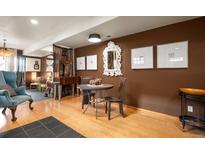 Cozy dining area featuring a round table, stylish chairs, and unique wall decor on hardwood floors at 469 Elati St, Denver, CO 80204