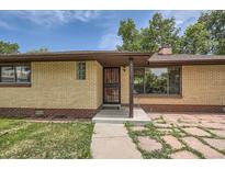 Charming home with a brick facade and inviting front door, featuring a well-manicured walkway and decorative details at 5600 Dover St, Arvada, CO 80002