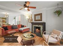 Cozy living room features a fireplace, ceiling fan, hardwood floors, and a comfortable seating area at 2336 N High St, Denver, CO 80205