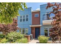 Contemporary blue townhouse with brick accents, a small balcony, and lush landscaping creating inviting curb appeal at 2346 Central Park Blvd, Denver, CO 80238
