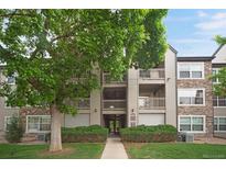 Multi-story condo building with stone accents, balconies, and lush landscaping at 9160 E Arbor Cir # F, Englewood, CO 80111
