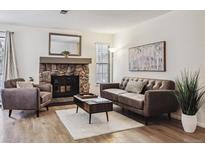 Inviting living room features a stone fireplace and modern furnishings at 10960 W Florida Ave # 113, Lakewood, CO 80232