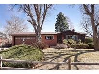 Charming one-story home featuring a well-manicured lawn, a brick facade, and an attached garage at 1288 S Drexel Way, Lakewood, CO 80232