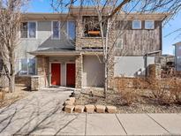 Stylish townhome featuring a stone facade, bright red doors, and modern architectural details at 9300 E Florida Ave # 1001, Denver, CO 80247