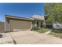 Split level home featuring beige siding and a two car garage in a suburban neighborhood at 19502 E Buchanan Pl, Aurora, CO 80011