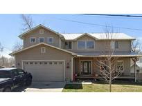 Two-story home featuring a large garage, neutral siding, and a covered porch at 11870 W 13Th Ave, Lakewood, CO 80401