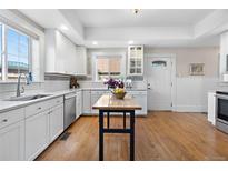 Bright kitchen features white cabinets, stainless steel appliances, and a butcher block island at 7996 Bradburn Blvd, Westminster, CO 80030