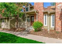 Charming townhome featuring a brick facade, inviting front entrance, and a well-maintained landscaped yard at 14093 E Radcliff Cir, Aurora, CO 80015