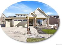 Charming home featuring a three car garage, stone accents, and a well maintained lawn at 5474 Espana St, Denver, CO 80249