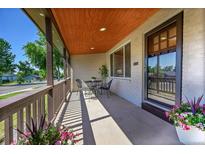 Charming covered front porch with seating area, perfect for relaxing and enjoying the outdoors at 4268 S Delaware St, Englewood, CO 80110