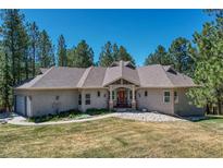Charming home with a red front door, beautiful lawn and a well-maintained landscape at 4726 Pinon Dr, Elizabeth, CO 80107