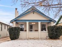 Charming bungalow with a quaint front porch, blue trim, and brick accents, nestled in a peaceful neighborhood at 2377 Cherry St, Denver, CO 80207