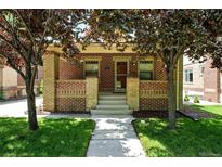 Charming brick home with a cozy front porch and well-manicured lawn, perfect curb appeal at 2549 Holly St, Denver, CO 80207
