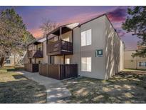 Inviting condo building with private balconies, manicured lawn, and a peaceful walking path at 9700 E Iliff Ave # B13, Denver, CO 80231