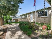 Charming brick home featuring a welcoming front yard with lush landscaping and a cozy seating area at 207 Short Pl, Louisville, CO 80027