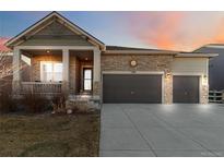 Charming single-Gathering home with stone accents, a covered porch, a three-car garage, and manicured landscaping at 1588 Blackwood Ct, Erie, CO 80516