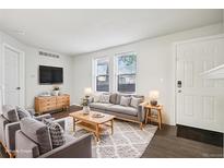 Bright living room with modern decor, wood floors, and large windows at 6705 S Field St # 803, Littleton, CO 80128