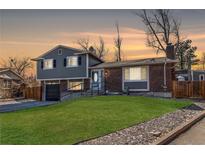 Charming two-story home with a well-manicured lawn, a brick facade, and an attached garage at 2863 S Biscay Ct, Aurora, CO 80013