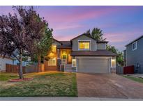Charming two-story home featuring a well-manicured lawn and an attached two-car garage at 17166 Yellow Rose Way, Parker, CO 80134