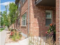 Brick building with manicured landscaping including trees, grass, and flowers lining the sidewalk at 6485 E Cedar Ave, Denver, CO 80224