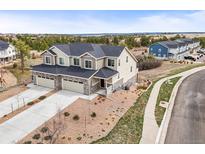 Aerial view of large modern homes with two-car garages, desert landscaping and blue skies at 650 Bishop Pine Way, Castle Rock, CO 80104