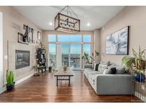 Bright living room with fireplace and access to a balcony boasting city views at 1488 Madison St # 505, Denver, CO 80206