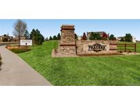 Attractive community entrance with stone signage, manicured lawn and directional sales office arrow at 5603 Twilight Way, Parker, CO 80134