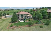 Expansive exterior of home features lush lawn, mature trees and landscaping, and views of surrounding community at 5603 Twilight Way, Parker, CO 80134