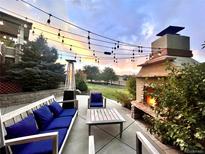 Cozy patio with ample seating, outdoor fireplace, heater, and string lights for evening relaxation at 5603 Twilight Way, Parker, CO 80134